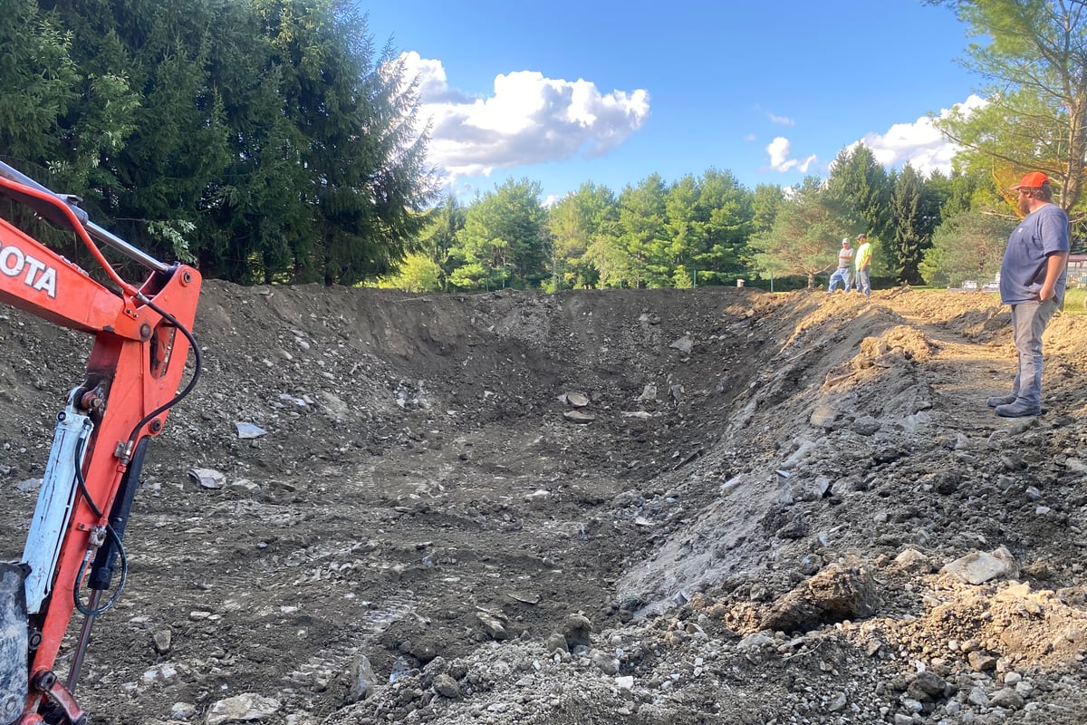 Excavator cutting and clearing a building site