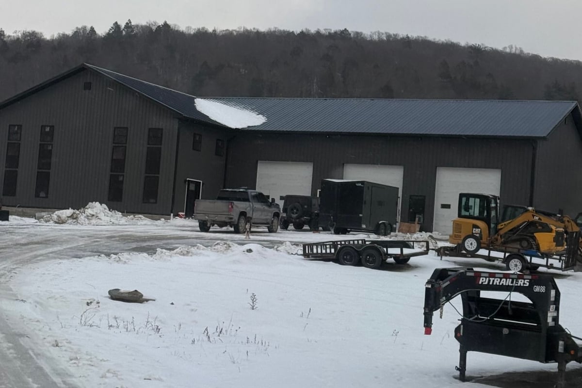 Finished dark metal building with overhead doors in winter